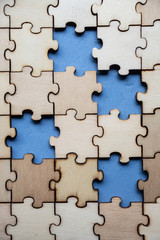 Wood jigsaw puzzle on blue background, business concept