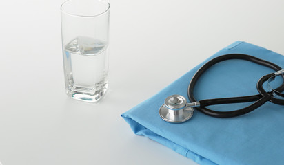 A stethoscope shaping a heart on a medical uniform, closeup, selective focus