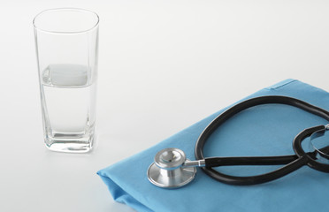 A stethoscope shaping a heart on a medical uniform, closeup, selective focus