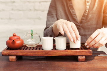 a girl in a gray linen shirt arranges a royal ceremony, classical accessories for a tea ceremony. Concept of healthy food and traditional drinks