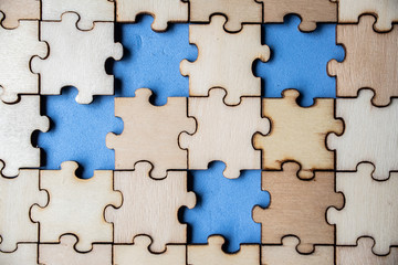 Wood jigsaw puzzle on blue background, business concept