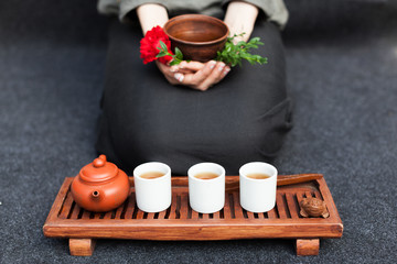 Herbal tea in a ceramic plate in female hands. The concept of nontraditional treatment of colds. Flu. Healthy Eating and Vitamins
