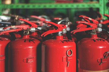 closeup red fire extinguisher with soft-focus and over light in the background