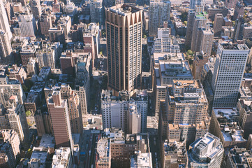 Fototapeta na wymiar Aerial view of Downtown Manhattan towards the East River Side, close-up on roads structure, skyscrapers, and urban density, with pink hazy filter, in New York City, USA