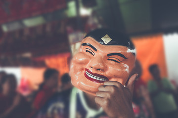 Popper smiling mask in Chinese new year lion dance shows . old man chinese with blur background color vintage style.