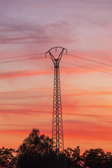 Un pylône électrique durant un coucher de soleil et un ciel coloré