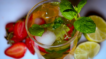 Lime, mint, strawberry, transparent glass, ice cubes.