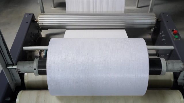 The resulting polypropylene sleeve for the manufacture of bags is wound on large reels. drum for winding sleeves of woven polypropylene yarns. PP bag production line