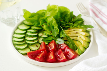 Vegetable salad with avocado and flax seeds on a light background, vegan food.