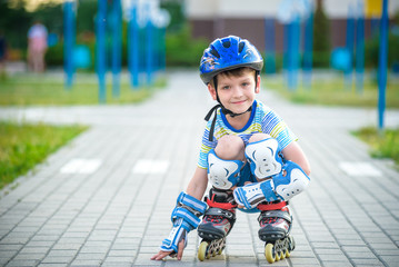 Smiling boy with inline skates and protective gear