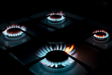 burning four gas cookers, in the dark, closeup
