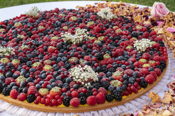 A large berry covered custard tart.