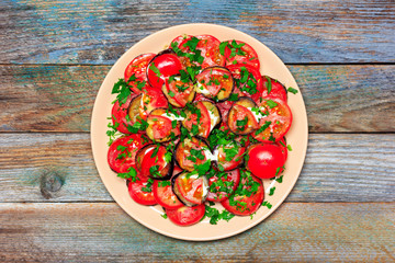 fried eggplant with tomato, garlic and mayonnaise on a wooden retro background, top view of a closeup