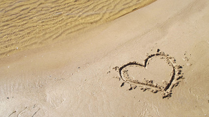 Painted heart on the sand.Rest on the river Bank.