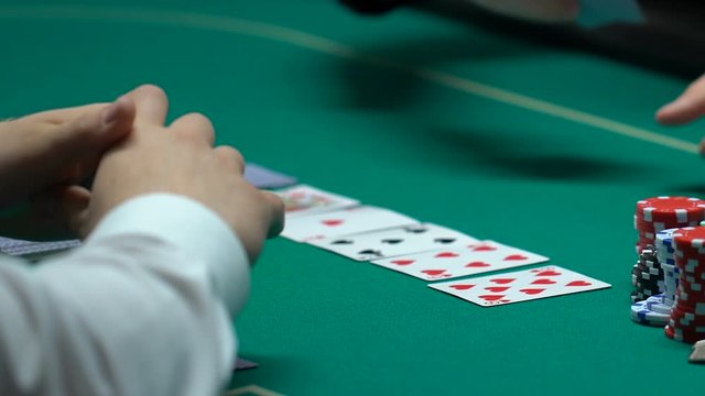 Man winning poker, grasping tokens and house keys, fortunate evening, closeup