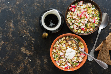 Okroshka on a dark background. Russian dish cold soup okroshka. Top view, copy space.