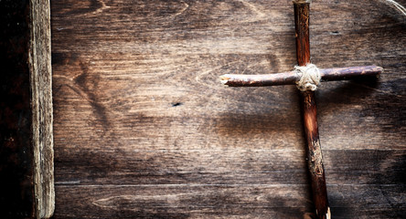 Religious old book on a wooden table. A religious cross tied wit