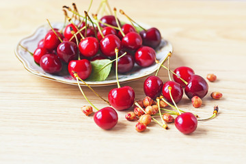 Obraz na płótnie Canvas Plate of cherries on a wooden background