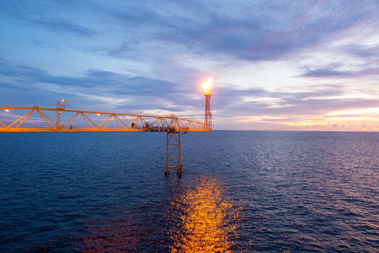 flape bridge of offshore construction platform for exororation and production oil and gas with bridge in evening time for power energy of the wolrd concept