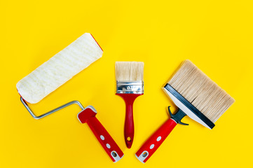 Professional house painter, work tools on yellow background