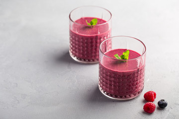 Mixed berry smoothie with mint on light concrete background, copy space
