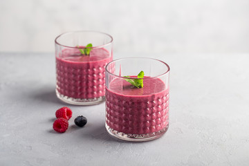 Mixed berry smoothie with mint on light concrete background, copy space