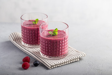 Mixed berry smoothie with mint on light concrete background, copy space