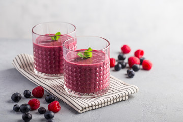 Mixed berry smoothie with mint on light concrete background, copy space 