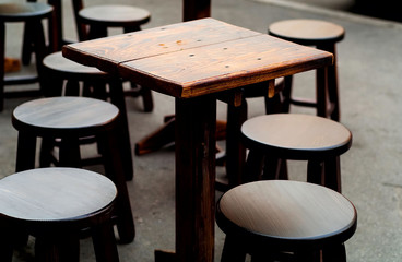 wooden round table and chairs outdoors, concept of home cafe, natural light, copy space, closeup.
