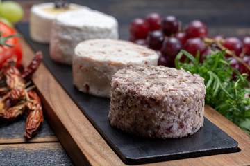 French soft cheeses, variety of different taste goat milk natural cheeses on granite plate close up sesrved as dessert