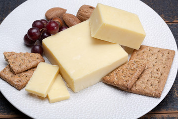 Block of aged cheddar cheese, the most popular type of cheese in United Kingdom and USA, natural cheese made from cow milk