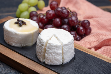 French soft cheeses, variety of different taste goat milk natural cheeses on granite plate close up sesrved as dessert