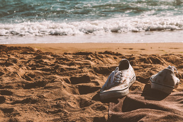 Sneakers left in a sandy beach 