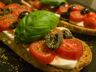 Bruschetta with tomato, mozzarella, basil and olives. 