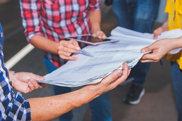 Close up of hand engineer meeting for architectural project working with partner and engineering tools on workplace.
