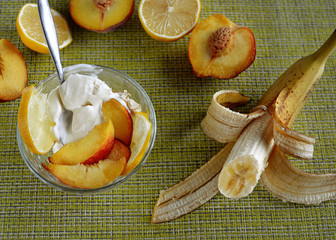 Fruit platter with ice cream in a glass bowl surrounded by different fruits
