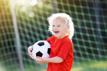 Kids play football. Child at soccer field.