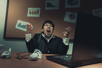 Asian businessman under stress due to excessive work,Feeling exhausted,Young clerk has a problem in a office,sad man from work,Angry messy man concept