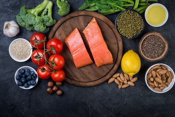 Fresh  fish, vegetables, fruits, nuts on dark  background, top view.  Ingredients for healthy cooking. Healthy food concept.