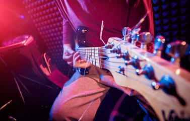 Fototapeta na wymiar Young man playing on the guitar in sound recording studio.