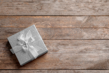 Fototapeta premium Beautiful gift box on wooden background, top view
