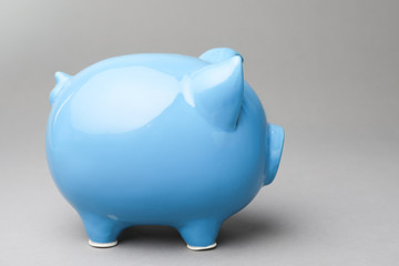 Cute blue piggy bank on gray background