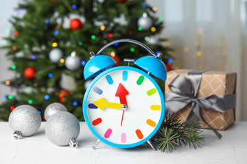 Retro alarm clock, gift and festive decor on table. Christmas countdown
