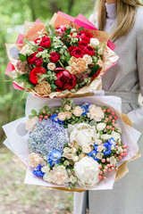 Young girl holding a beautiful spring bouquet. flower arrangement with hydrangea and peonies. Color light blue. The concept of a flower shop, a small family business