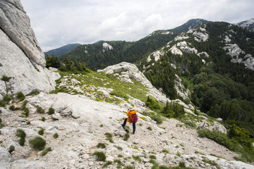 Hiker on path to Balinovac peak on Velebit mountain, Croatia. 