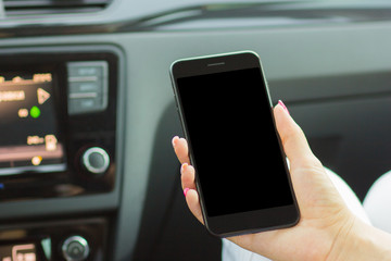girl sitting in the car holding a smartphone in her hand, close-up