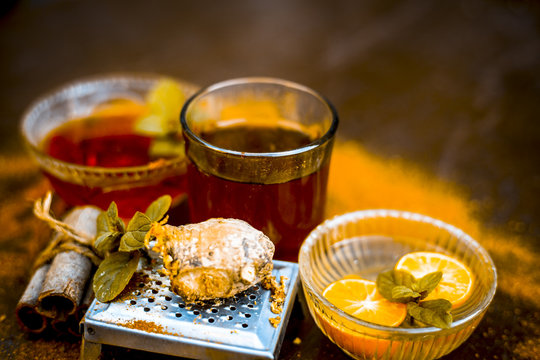 Close up of Ayurvedic home remedy for common cold: Fresh organic ginger ( grated) , warm water, cinnamon stick, honey, and lemon juice.