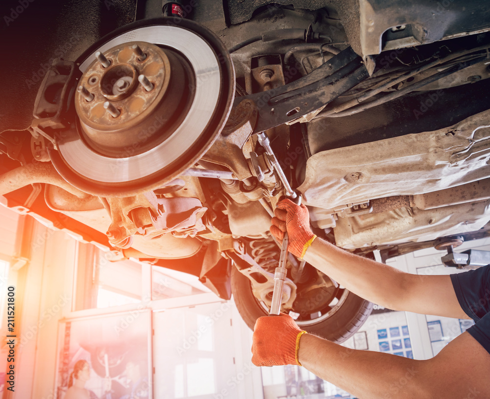 Wall mural car mechanic repair car suspension of lifted automobile at repair service station