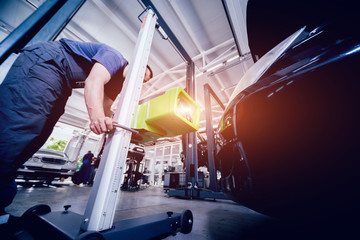 Worker checks and adjusts the headlights of a car's lighting system