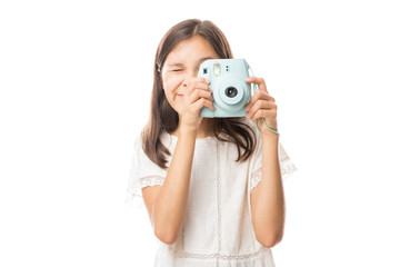 Fototapeta premium Portrait on a young girl clicking photos with camera isolated on white background